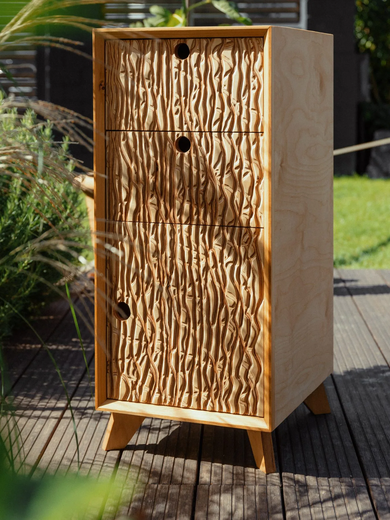 Unterschrank mit Relieffronten und schrägen Beinen auf einer Terrasse