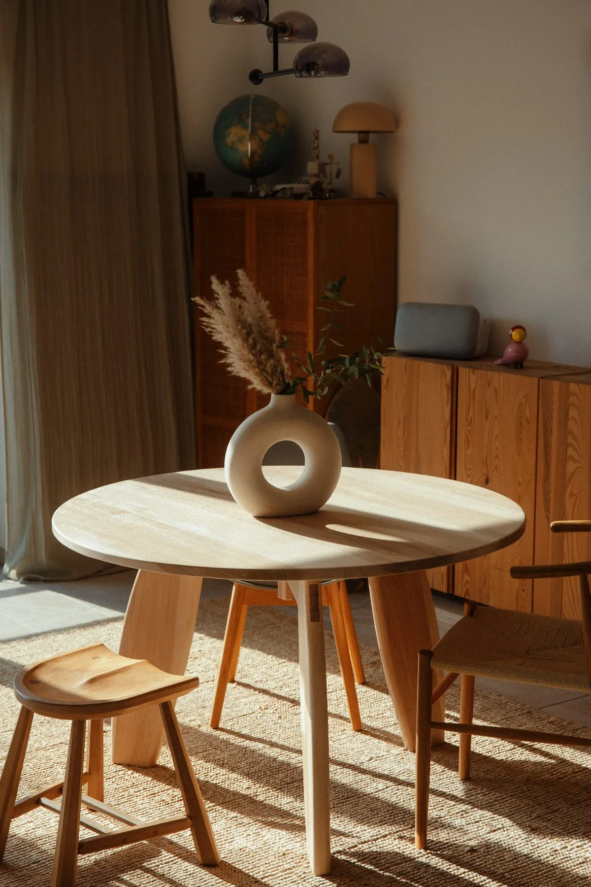 Esstisch aus Esche mit Hocker und Stuhl in einem hellen Wohnraum